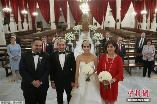 资料图：当地时间2020年6月20日，约旦安曼，当地一对新人Zaid Masarweh和Leen Aghabi在教堂举办了一场小型婚礼，并且通过Zoom软件对他们在海外的家人直播了婚礼。?